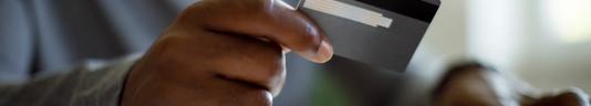 person's hand holding a payment card
