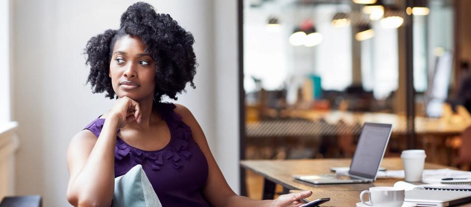 Black woman looking out the window thinking