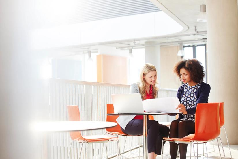 Business people in a discussion over laptop and documents