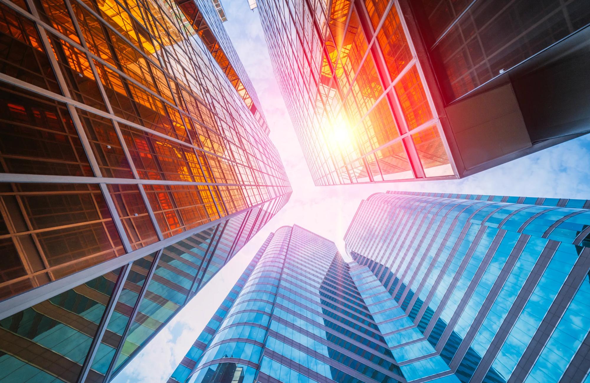 skyscrapers from below with the sun reflecting off glass facade