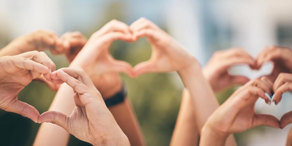 many people's hands making heart signs