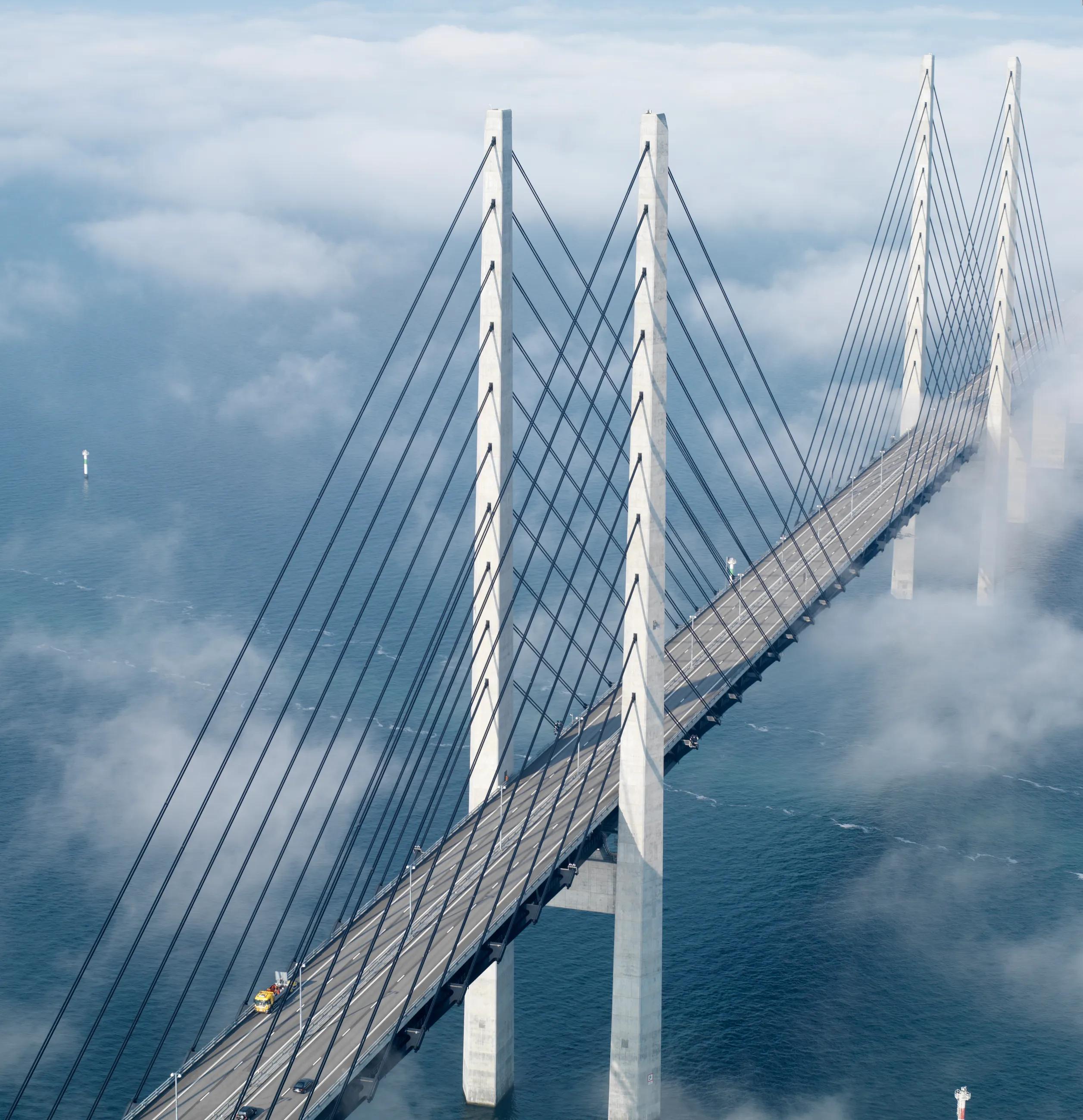 driving bridge over water with clouds