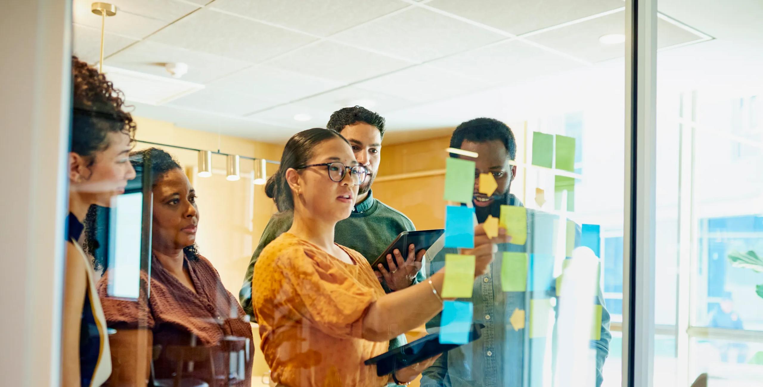 Menschen, die sich mit Haftnotizen vor der Plantafel treffen | Vielfalt, Gleichberechtigung und Integration