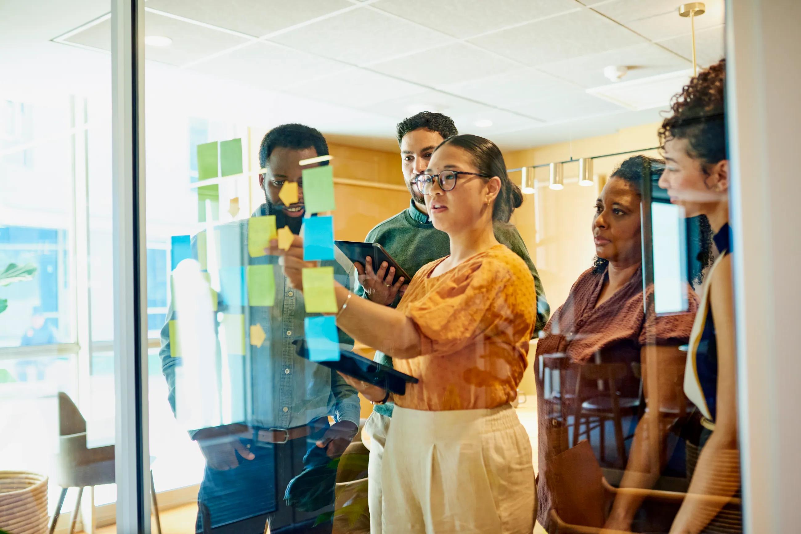 People meeting in front of planning board with sticky notes | Diversity, Equity and Inclusion